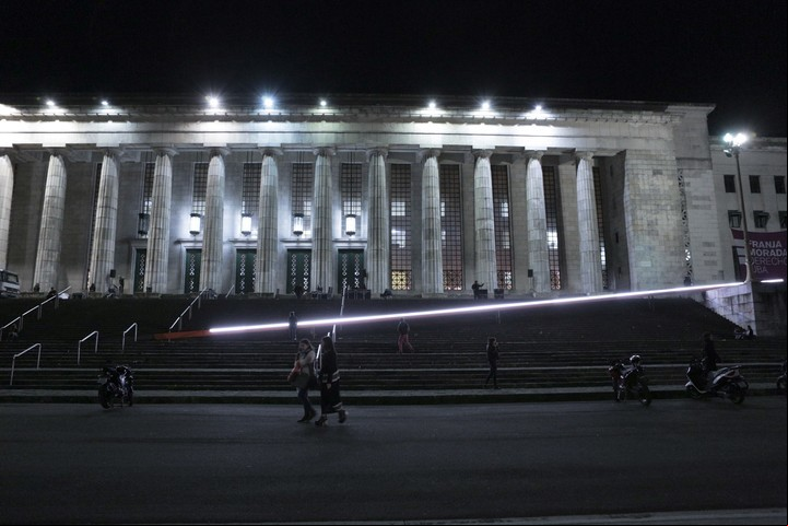 La línea de Buenos Aires. 47 metros de luz y metal pintado de naranja, cruzados diagonalmente en la escalera de la Facultad de Derecho de la UBA.