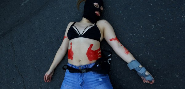 Una manifestante yace en el suelo durante una marcha que exige el fin del sexismo y la violencia de género en Santiago de Chile el 6 de junio de 2018. Foto: REUTERS/Ivan Alvarado