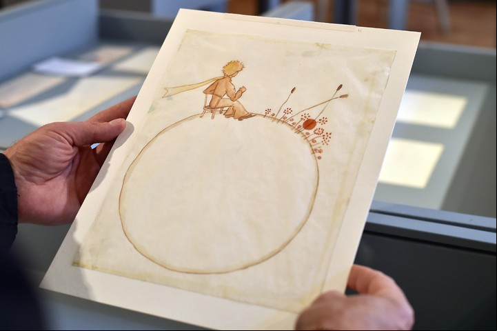 (FILES) This file photo taken on May 17, 2017 shows a person holding a drawing of 'Le Petit Prince' by Antoine de Saint-Exupery at the Museum of Old Toulouse prior to the sale of a set of 12 drawings and 7 letters by Saint-Exupery to be auctioned in Paris on June 14, 2017. 
Two watercolours of 'Le Petit Prince' (The Little Prince) by Antoine de Saint-Exupery were sold on June 14, 2017 for 500, 000 euro (560,149 USD) according to the Artcurial auction house.  / AFP PHOTO / REMY GABALDA / RESTRICTED TO EDITORIAL USE - MANDATORY MENTION OF THE ARTIST UPON PUBLICATION - TO ILLUSTRATE THE EVENT AS SPECIFIED IN THE CAPTION francia  subasta dibujos hechos por el autor del principito remates subastas