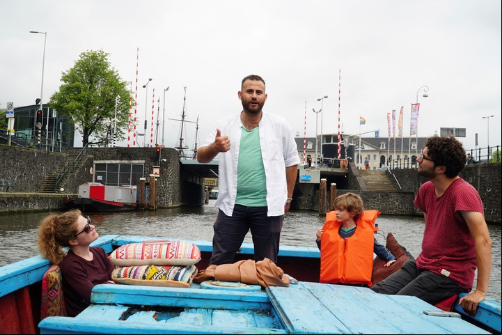 Una familia de turistas disfruta de un paseo por los canales de Ámsterdam en un barco pesquero que en su día fue utilizado como patera para cruzar el Mediterráneo entre África y Europa. EFE/ Imane Rachidi