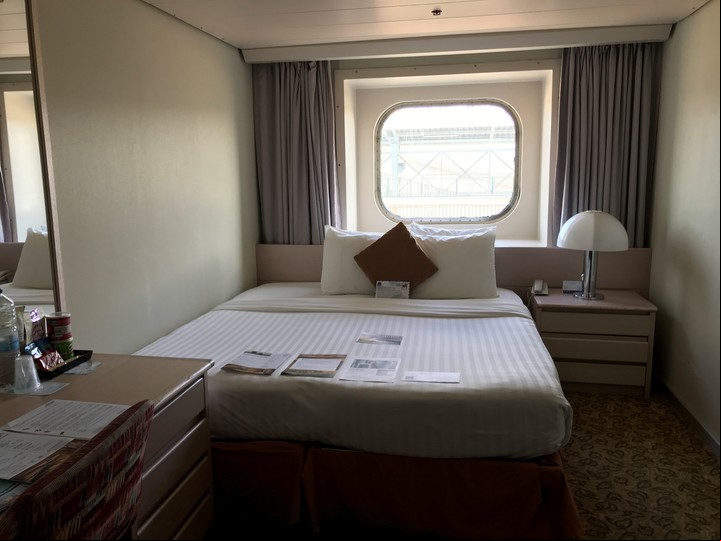 Limpio y ordenado por la tripulación, el camarote con ventana de Pullmantur tiene los diarios de a bordo al pie de la cama.