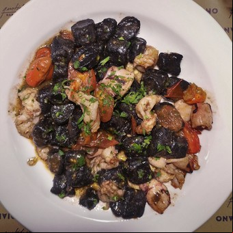 Ñoquis negros con frutos de mar