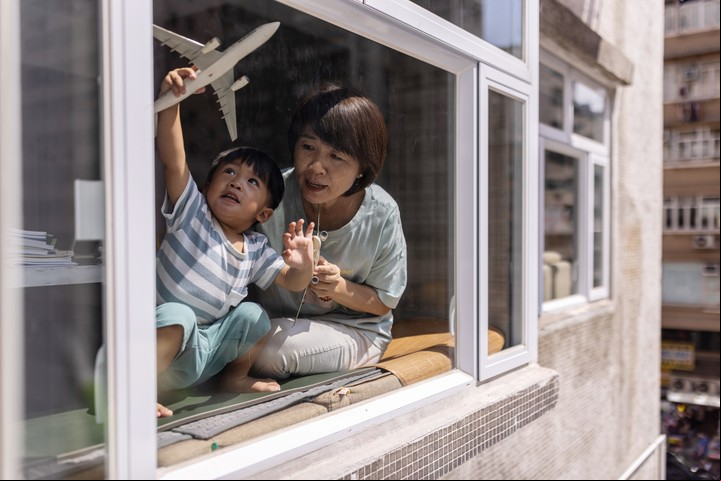 Connie Cheung, quien terminó una larga carrera en Dragonair cuando cerró en 2020 para convertirse en niñera posparto, con su nieto Kason Ip, de 2 años, en Hong Kong, el 20 de julio de 2022. . Foto Louise Delmotte/The New York Times.