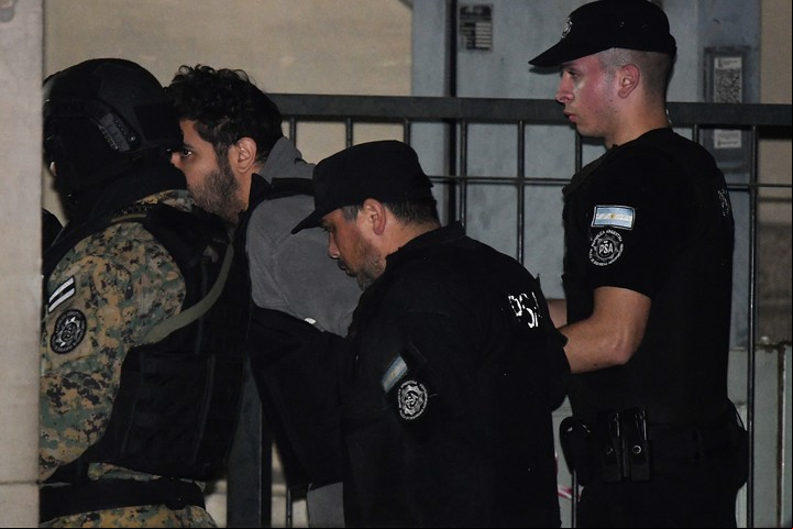 Fernando Sabag Montiel sale de los tribunales rodeado de policías, este martes a la noche. Buscó desligar a su novia del atentado, aunque por segunda vez se negó a prestar declaración indagatoria. Foto AP