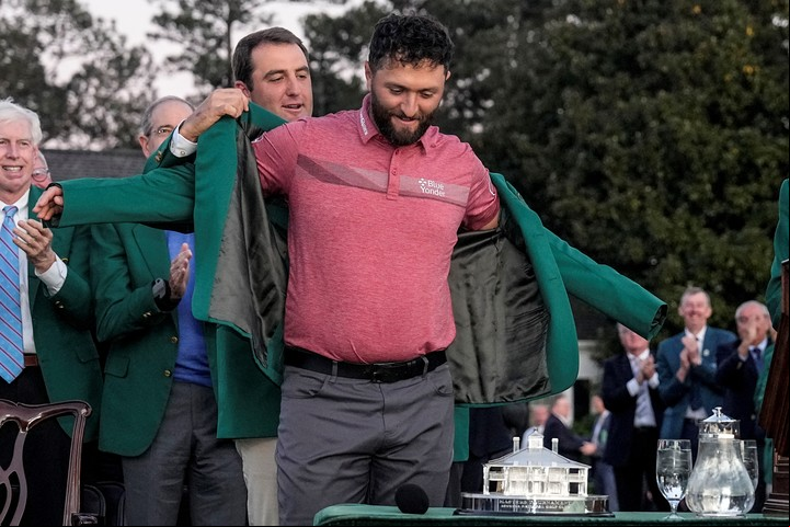 Scottie Scheffler le pone el saco verde a Jon Rahm. Foto: AP