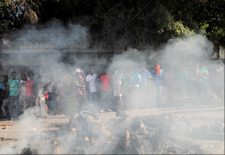 Humo y habitantes desconcertados tras el estallido de violencia del lunes en Puerto Príncipe, Haití. Foto: REUTERS