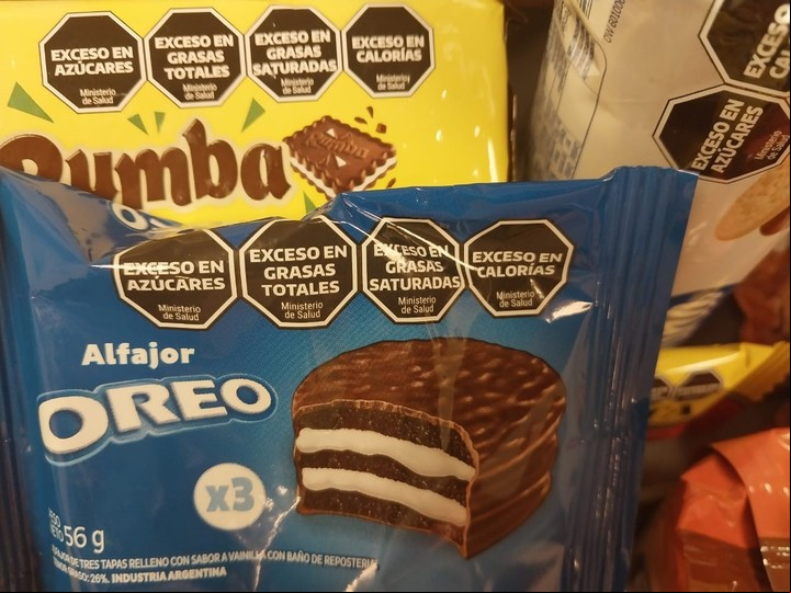 Un alfajor de chocolate y galletitas de chocolate con cuatro sellos negros.