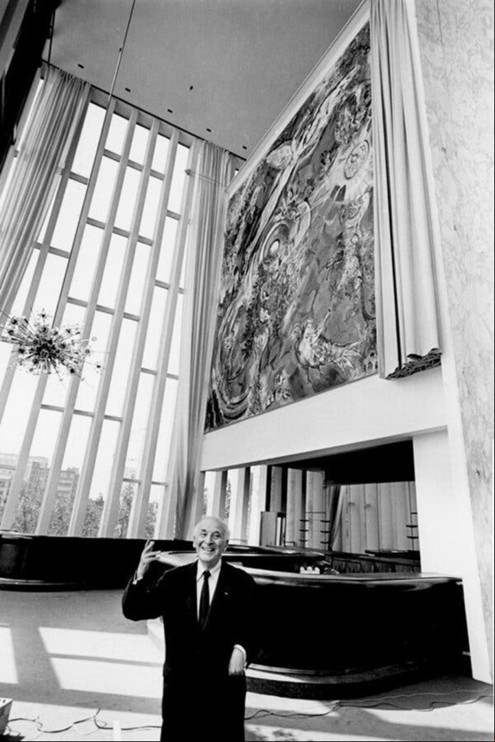 Marc Chagall in 1966, en el teatro Metropolitan Opera de New York, bajo uno de sus cuadros. Foto de Eddie Hausner/The New York Times