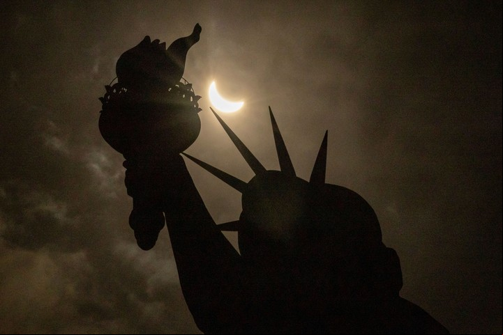 La luna cubre parcialmente el sol detrás de la Estatua de la Libertad durante el eclipse. Foto: AP
