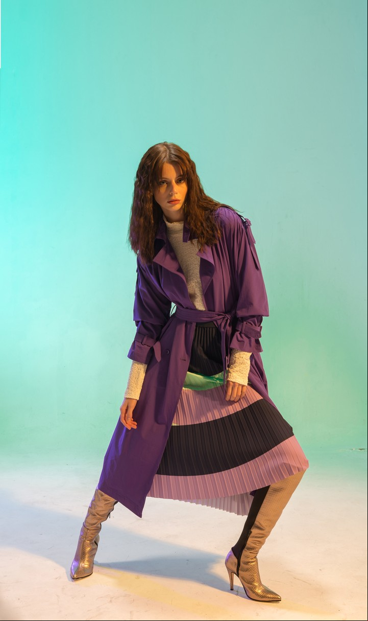 Violeta y lila. Polera off white con textura, falda plisada varios colores y trench violeta (Las Pepas). Bucaneras metalizadas con neoprene (Puli D. Shoes) y aros bicolor (Luna Garzón). Foto: Esteban Leyba.