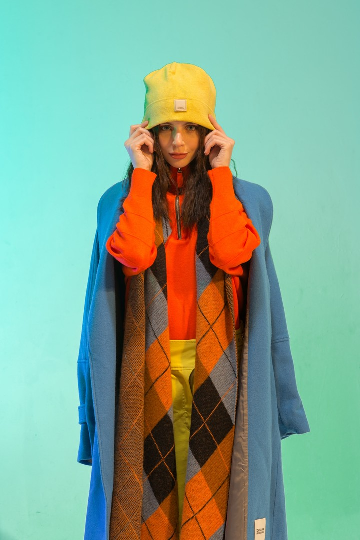 Anaranjado neón. 
Suéter polera con cierre, pantalón con detalles en cintura, saco de paño azul y gorro (Mishka) con bufanda cuadriculada (Blue Sheep). Foto: Esteban Leyba.