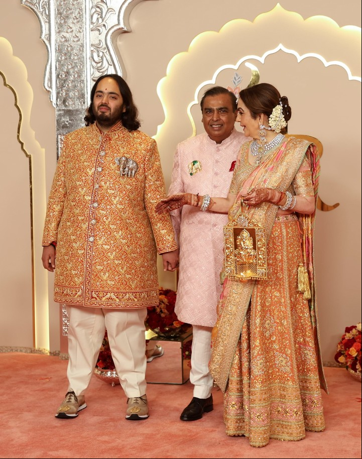 Mukesh Ambani y Nita posan junto a su hijo menor, Anant, de zapatillas. Foto: EFE