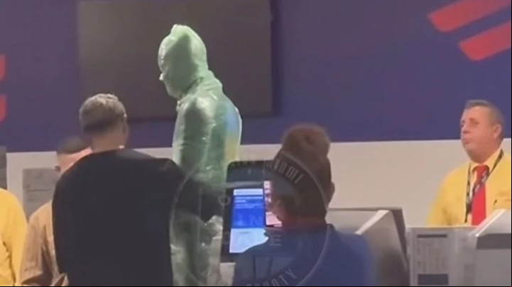 Un hombre envuelto en cinta adhesiva para equipajes se presentó en el mostrador de facturación (Captura de video).