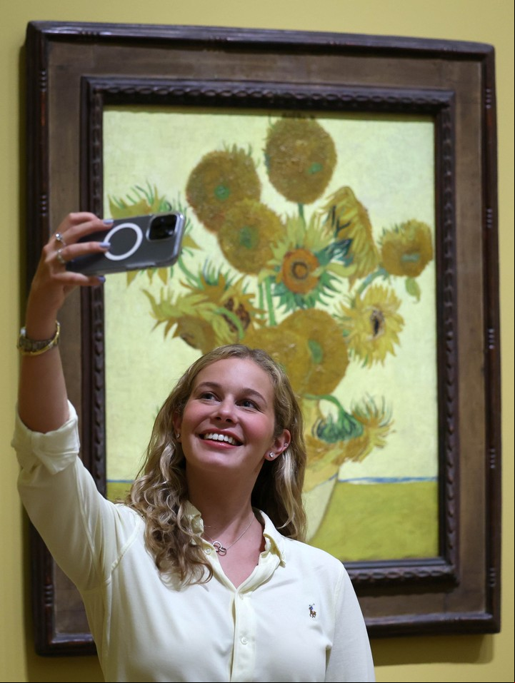 Una galerista posa para un selfie con la obra del artista holandés Vincent van Gogh titulada "Girasoles" (1888) durante un avance de la exposición "Van Gogh: Poetas y amantes" en la National Gallery de Londres. (Reino Unido, Londres) EFE/EPA/NEIL HALL