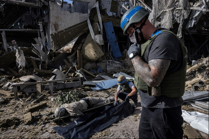 Ucranianos abren una bolsa para cadáveres de un soldado ruso muerto encontrado entre los escombros de un puesto fronterizo destruido en Sudzha, Rusia, 12 de agosto de 2024. (David Guttenfelder/The New York Times)