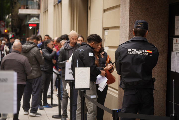 Un policía español observa una fila frente al consulado, en Buenos Aires, para hacer trámites de migración. Foto: Guillermo Rodriguez Adami