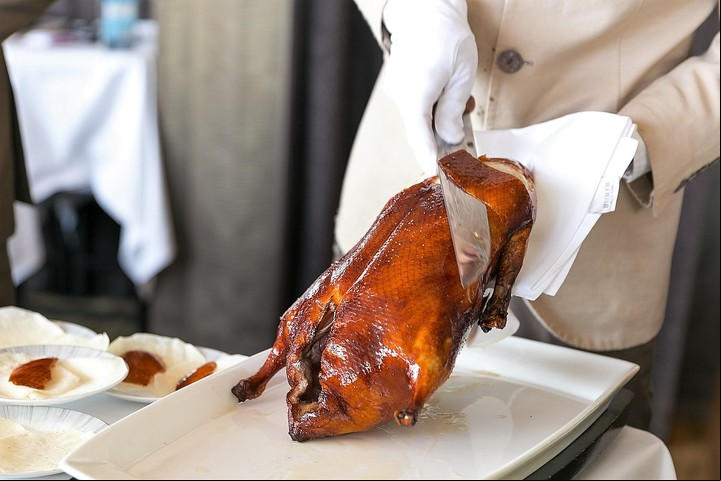 Un chef troza un pato asado pekinés. Foto: City Foodsters, CC BY 2.0 <https://creativecommons.org/licenses/by/2.0>, via Wikimedia Commons