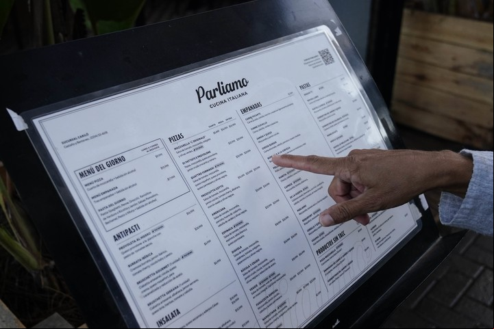 Mirando precios. Un turista consulta la carta de un restaurante. Foto Fernando de la Orden / Enviado especial