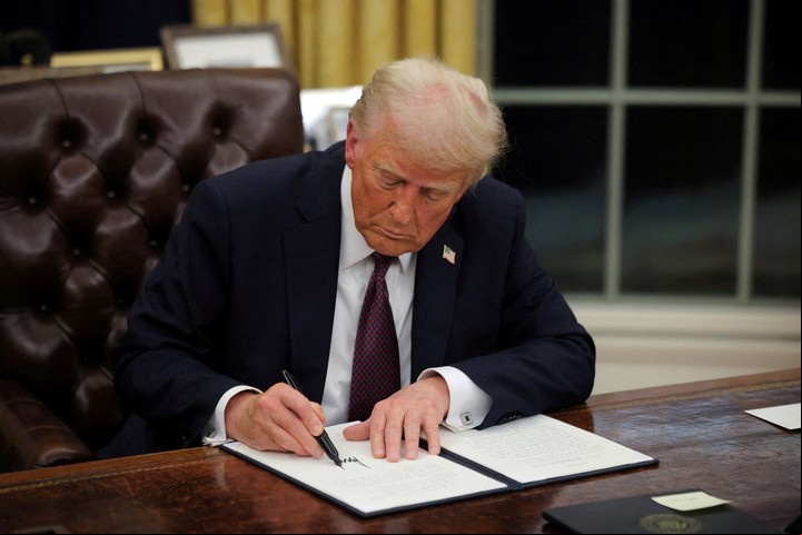 El presidente de Estados Unidos, Donald Trump, firma documentos mientras emite órdenes ejecutivas e indultos para los acusados del 6 de enero en la Oficina Oval de la Casa Blanca el Día de la Inauguración en Washington, Estados Unidos, 20 de enero de 2025. REUTERS/Carlos Barria/File Photo