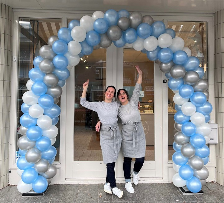 Nina y Marisol rodeadas de globos celestes y blancos en la apertura de su primer local, donde también tienen la producción.