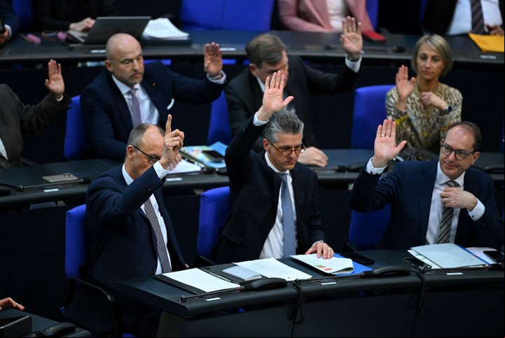 Friedrich Merz levanta la mano durante una sesión extraorindaria en el Bundestag. Foto: Reuters