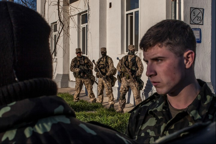 Soldados ucranianos miran hacia las tropas rusas que se acercan en Belbek, Crimea, 22 de marzo de 2014. Un nuevo plan de paz de Estados Unidos ofrecido a Rusia y Ucrania propone el reconocimiento estadounidense de la península, de la que Moscú se apoderó en 2014. (Mauricio Lima/The New York Times)