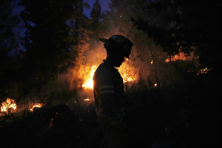 Bombero israelí intenta apagar incendios en la zona de Jerusalén. Foto: AP