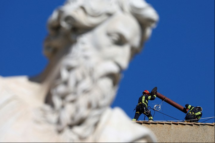 Los bomberos ya instalaron las chimeneas que arrojaran el humo blanco o negro. Foto Reuters /Guglielmo Mangiapane